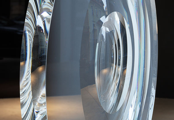 <i>Big Cylinder with Curved Surfaces 1/6</i>, 2022; 59.5 x 59.5 x 5 centimeters; clear optical glass 
