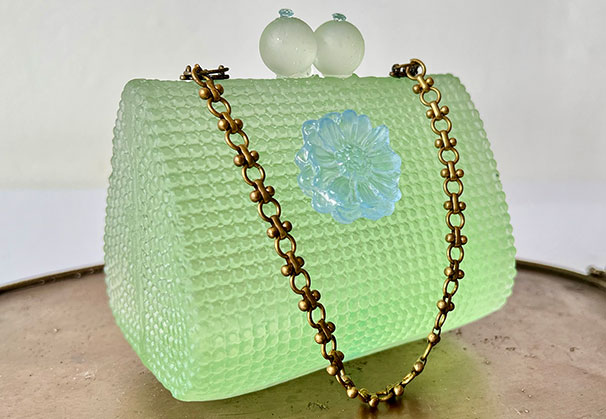<i>Tiny Bit</i>, 2024; Purse: 3 x 4 x 3.5 inches, Tray: 13 x 7 x 0.5 inches; glass, bronze, vintage chain, topaz