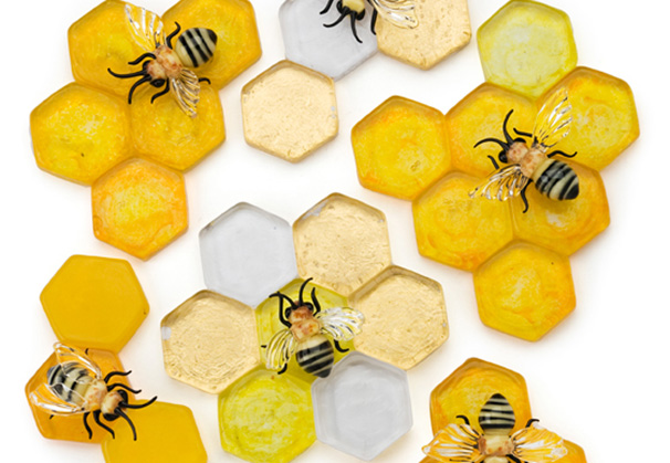<i>Bee Relevant</i>; section of installation of more than 500 honeycombs that can be arranged in any form spanning a few feet up to 20 feet; hot cast, flameworked, and gold leafed glass
